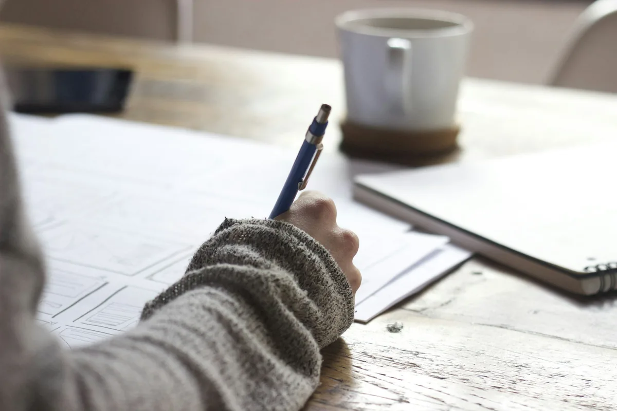 Adult learner writing study notes while preparing for the GED exam